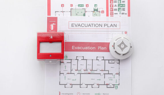 Evacuation plans, smoke detector and manual call point on white background