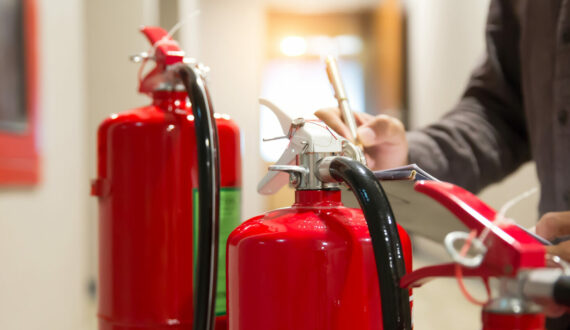 Fire engineering checking pressure gauge level of fire extinguishers tank in the building concepts of protection and prevent for emergency and safety rescue and fire training.