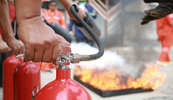 Employees firefighting training, Concept Employees hand using fire extinguisher fighting fire closeup